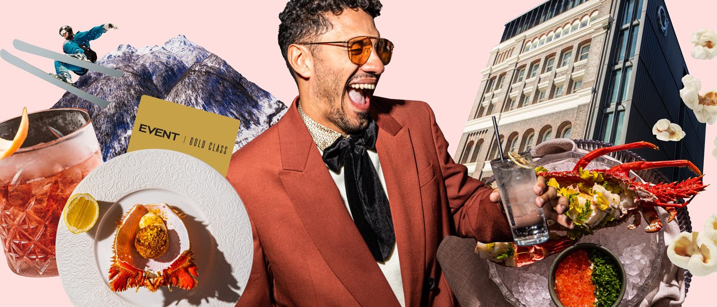 Smiling man in a brown suit surrounded by plated food, drinks, herbs, and a city building on a pink background.